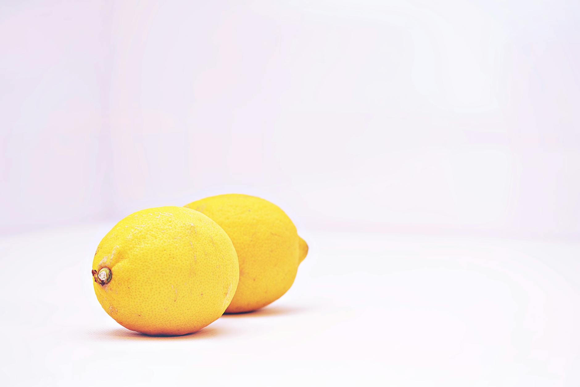 Vibrant yellow lemons on a white background symbolizing fresh sensation and novelty