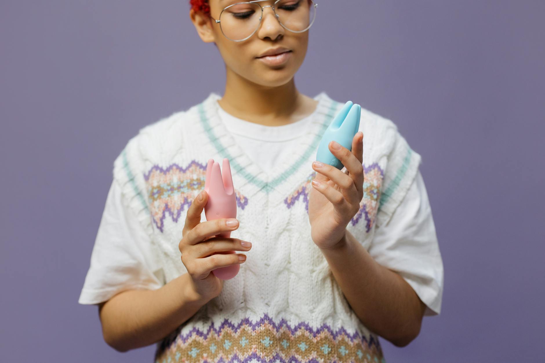 Woman holding silicone vibrators thoughtfully, representing gentle sensual recovery