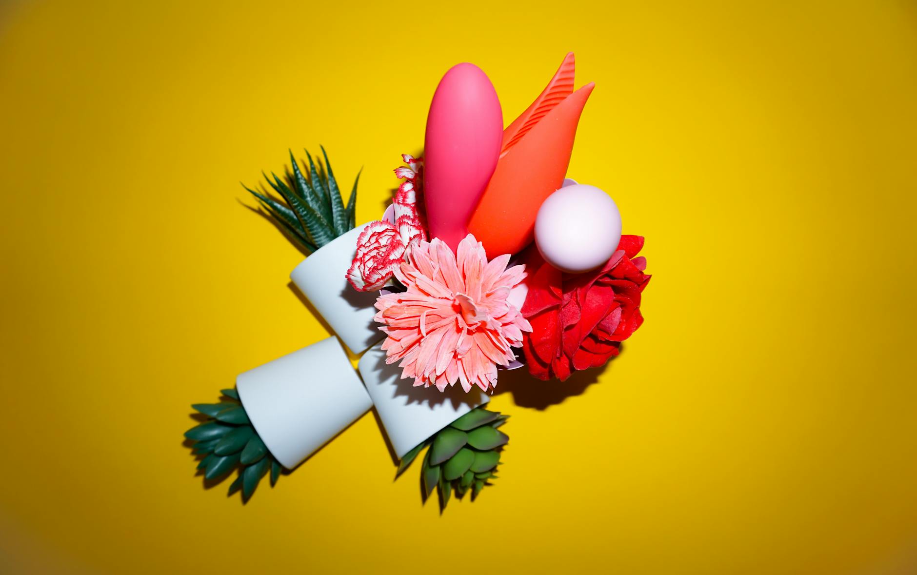 Colorful arrangement of flowers and abstract objects on a bright yellow background